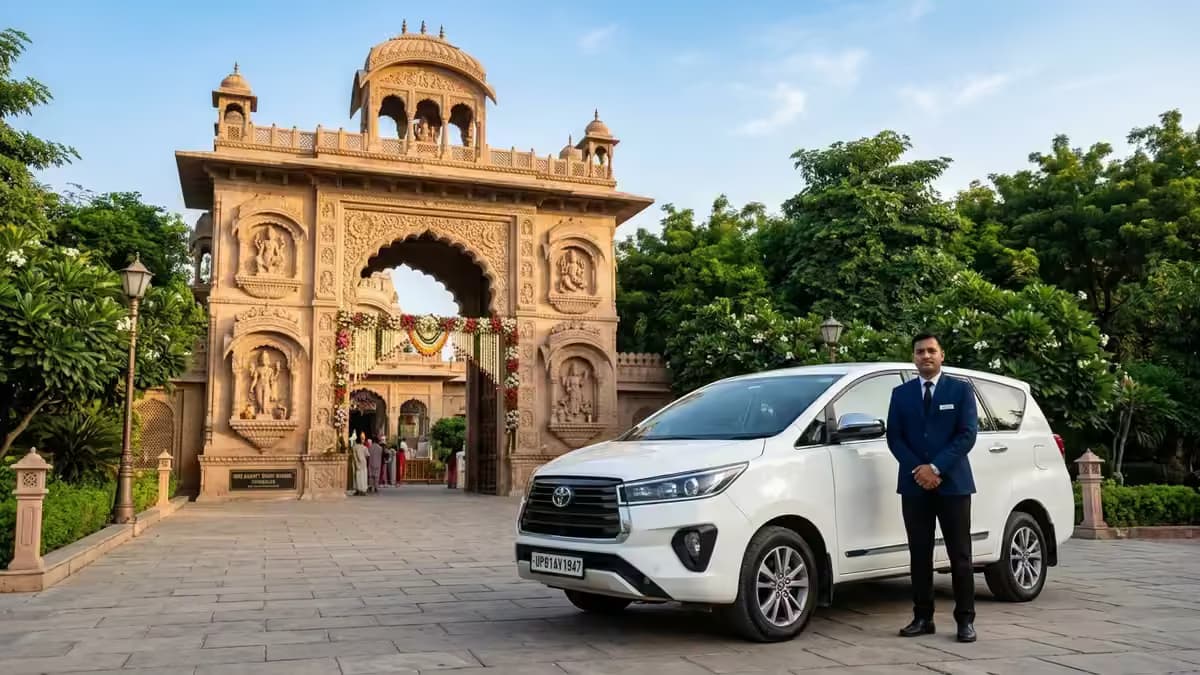 Spotless sanitized luxury Toyota Innova Crysta taxi with professional chauffeur in uniform parked outside grand Vrindavan temple arch